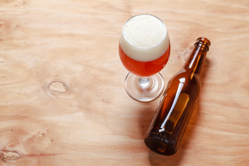 Beer glass and bottle on wood