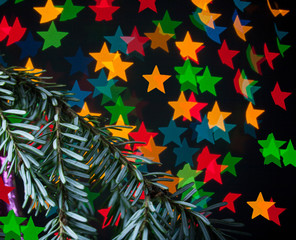 Christmas decorations, spruce branches  on black background with artistic bokeh - colored stars