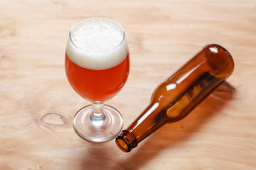Beer glass and bottle on wood