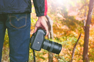 professional photographer with camera in autumn. Vintage tone.