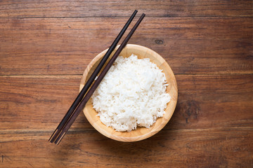 Rice in a bowl on wooden background