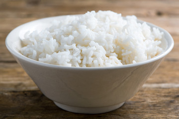 Rice in a bowl on wooden background