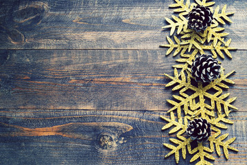 Christmas wooden background with decorative snowflakes and pine cones. View with copy space. Snowflakes on a wooden board.  Empty space for your text.