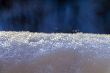 Snow bank against evening bokeh background. Selective focus.