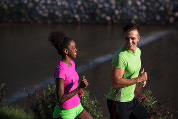 young smiling multiethnic couple jogging in the city