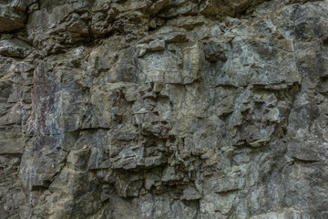 The stone wall of rock with cracks