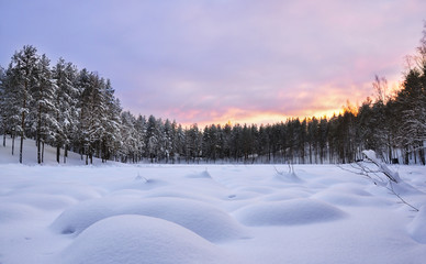Winter landscape. Frozen lake. Snowdrifts. Sunset