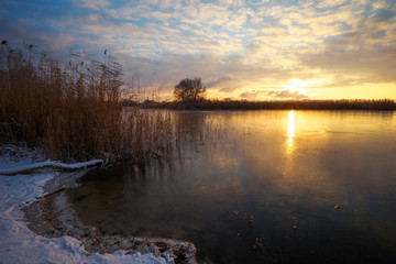 Fototapeta na wymiar Winter landscape with sunset sky and frozen river. Daybreak