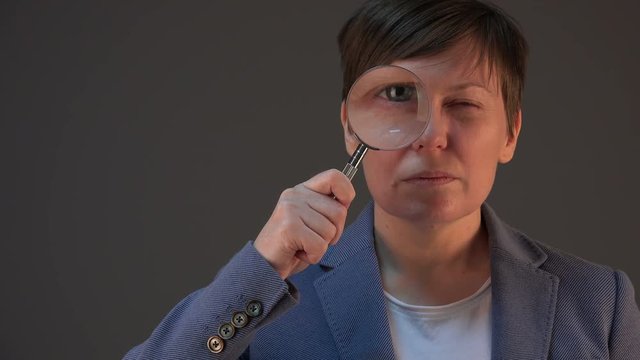 Female tax inspector with magnifying glass looking into papers and documents