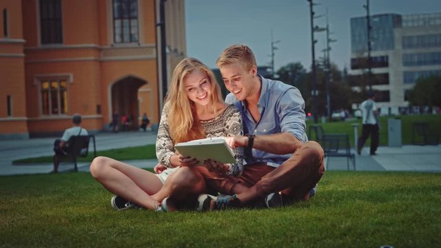 Cheerful couple relaxing with a tablet
