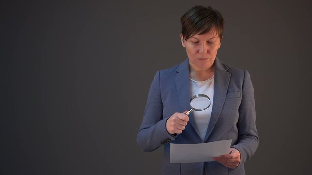 Female lawyer reading legal contract agreement disclaimer with magnifying glass, company's legal representative working