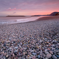 Colorful sunset on the shores of the English Channel. Pebble Beach. Sidmouth. Devon. England