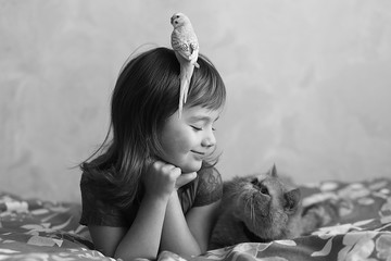 girl with a cat and a parrot on the bed