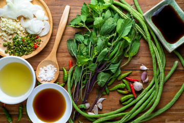 recipe book with fresh herbs and spices on wooden background, thai food.