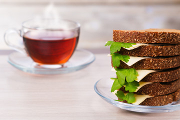 Bread, cheese and parsley with hot tea on the table.