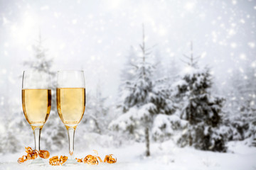 Christmas decorations and champagne against winter background