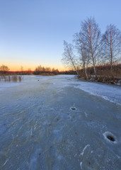 Sunset in the cold evening on the frozen lake.