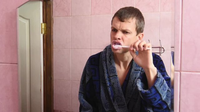 Young man brushing his teeth in the bathroom