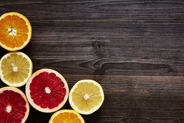 Fototapeta na wymiar several sliced organic citrus fruits on wooden surface
