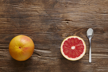 whole and sliced organic grapefruit with spoon ready to eat