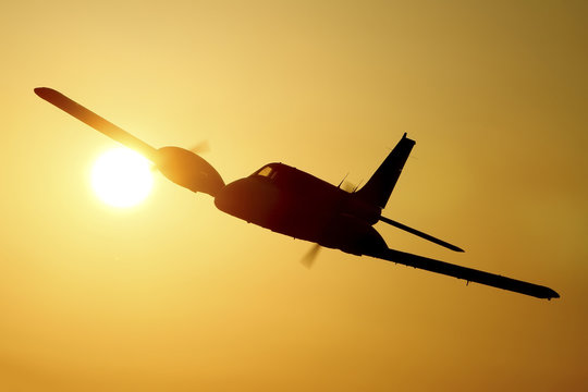 Airplane silhouette in the sunset /Two engine aircraft in the sky at sunset 