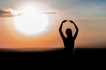 silhouette of a young girl on the sunset background