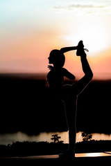 silhouette of a young girl on the sunset background