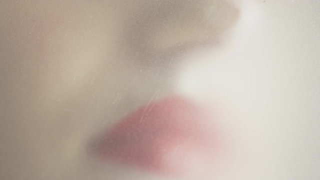 Woman's lips on matt glass