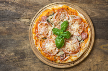 Hot pizza with melting cheese on a rustic wooden table. space for text 