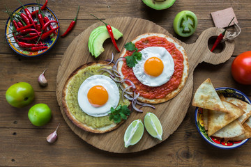 huevos divorciados, fried eggs on corn tortillas with salsa verde and  roja, mexican breakfast - 129493648
