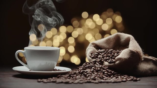 beautiful composition the Cup of hot coffee and coffee beans on the table, magic bokeh background