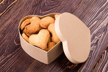 Cookies in box with lid. Biscuits in shape of heart. How to make pastry. Dessert baked at home.