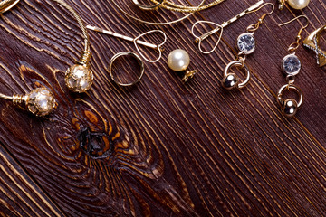 Jewelry on wooden background. Golden rings and earrings. Make a posh gift. Art of being a jeweler.