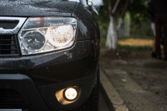 headlights of black car. Outdoors. With rain drops.