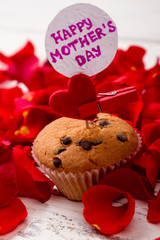 Mother`s Day card and muffin. Heart, cupcake, card and petals. Delicious present for mommy.