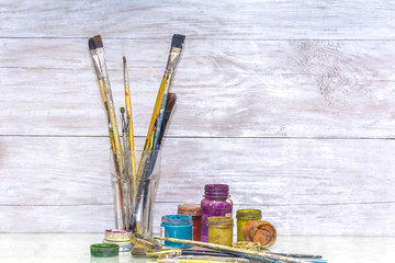 Multicolored plastic cans with paints. Artist workplace background. Old dirty Paints background. Colorful artist palette. Creativity, visual art concept. Art and craft.