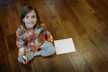 Youn Girl on Wood Floor with Paper and Pen