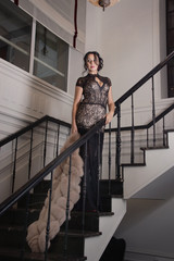 Beautiful  woman dressed in long lace dress in a vintage interio