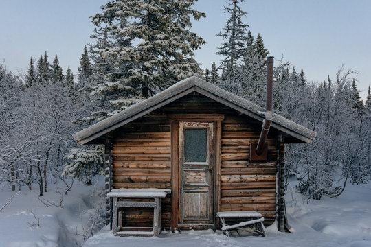 cabin in the woods in snowy frozen forest landscape