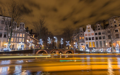 Tour boats leave light trails in front of the artwork 
