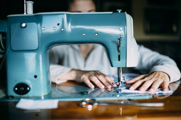 .Woman sewing with a sewing machine in his workshop