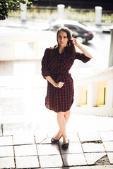 Fototapeta premium young pretty women with long windy hair in violet dress standing at stairs