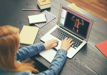 Woman watching sport training online on laptop. Fitness and sport blog.