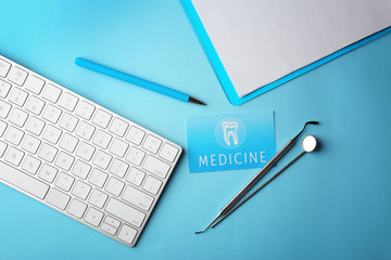 Business card, clipboard, keyboard and dental tools on blue background. Medical service concept