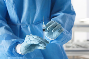 Surgeon holding syringe, closeup