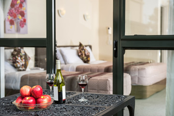 Red wine and apples are on the table.