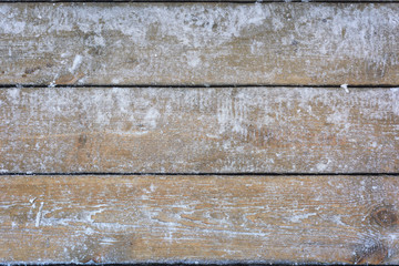 Naklejka premium Snow-covered wooden background, texture, frozen wood