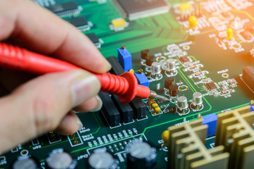 Male hands close up checking voltage on transistor