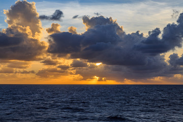 Fototapeta premium Sun among clouds over the ocean.