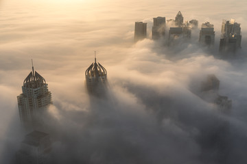 Rare early morning winter fog above the Dubai Marina skyline and skyscrapers ahead of sunrise in...